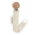 Baby pacifier holder with wooden top and gold polka dot strap on a white background