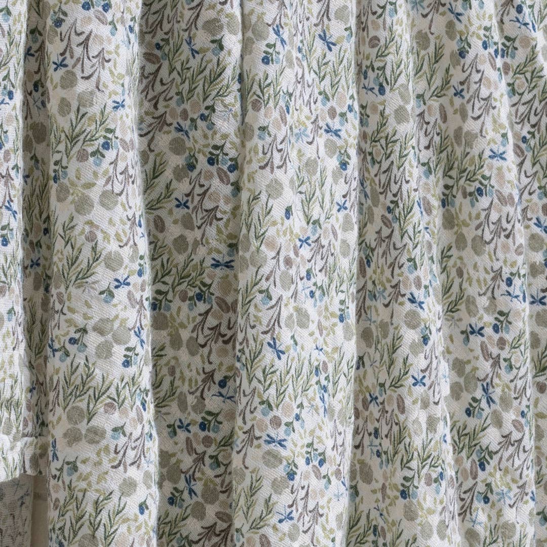 Floral patterned curtain with green, blue, and brown colors.