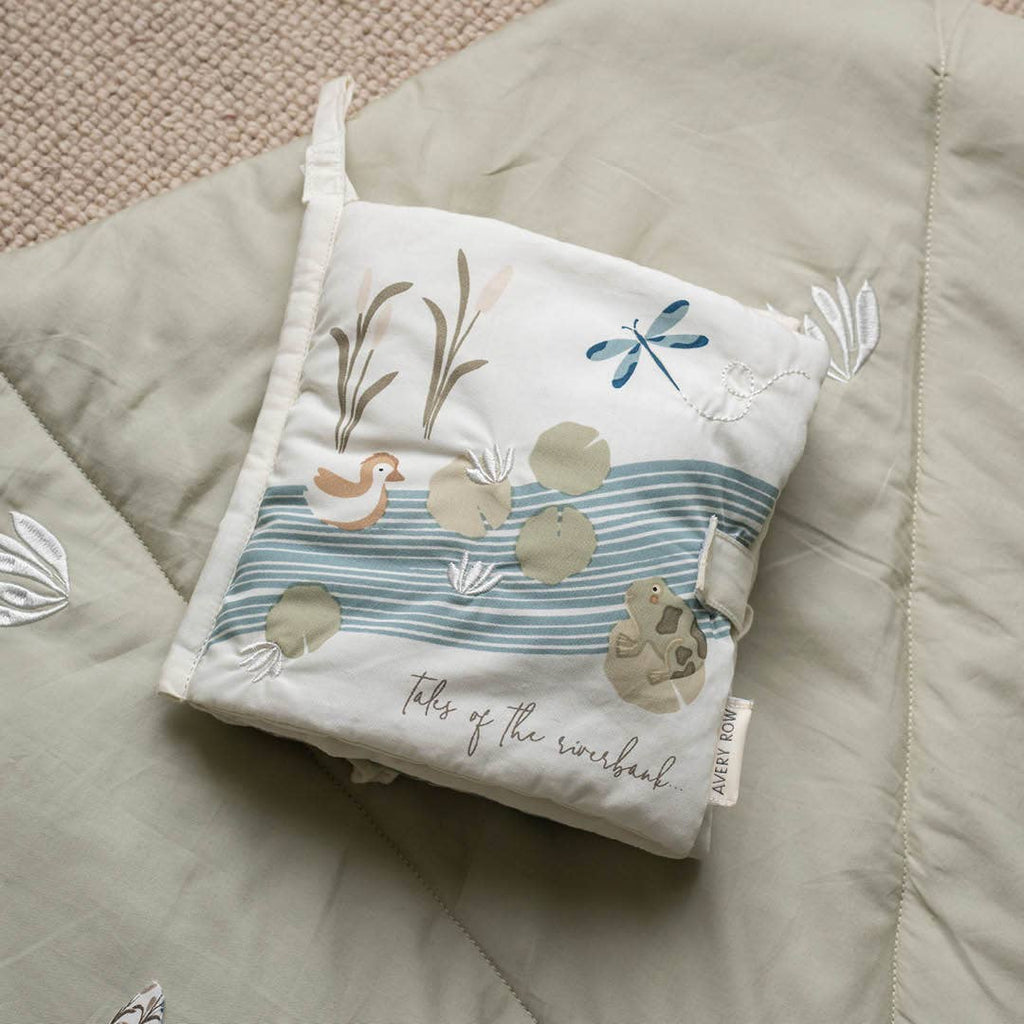 Small fabric book with nature-themed design on a textured surface