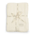 Folded cream-colored baby blanket with 'Avery Row' branding on a white background