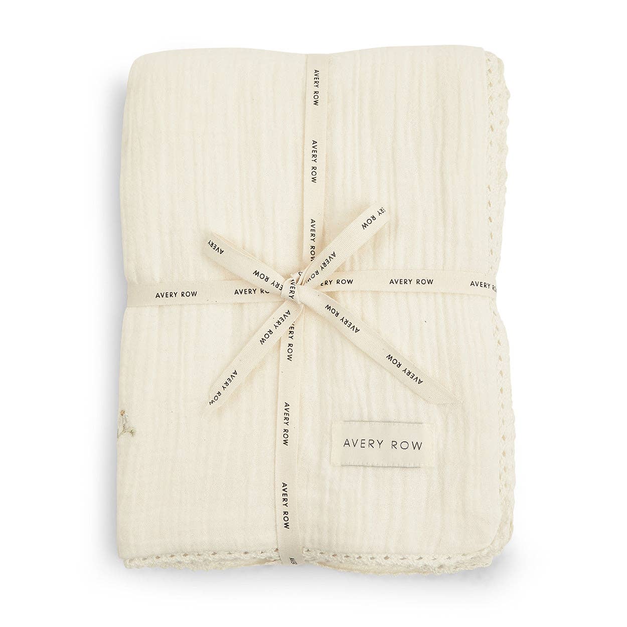 Folded cream-colored baby blanket with 'Avery Row' branding on a white background