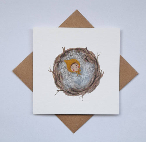 Card with a nest illustration featuring a baby in a yellow outfit, on a white background with a brown envelope.