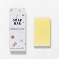 Yellow soap bar next to its packaging with 'Banks Lyon Botanical' branding on a light gray background
