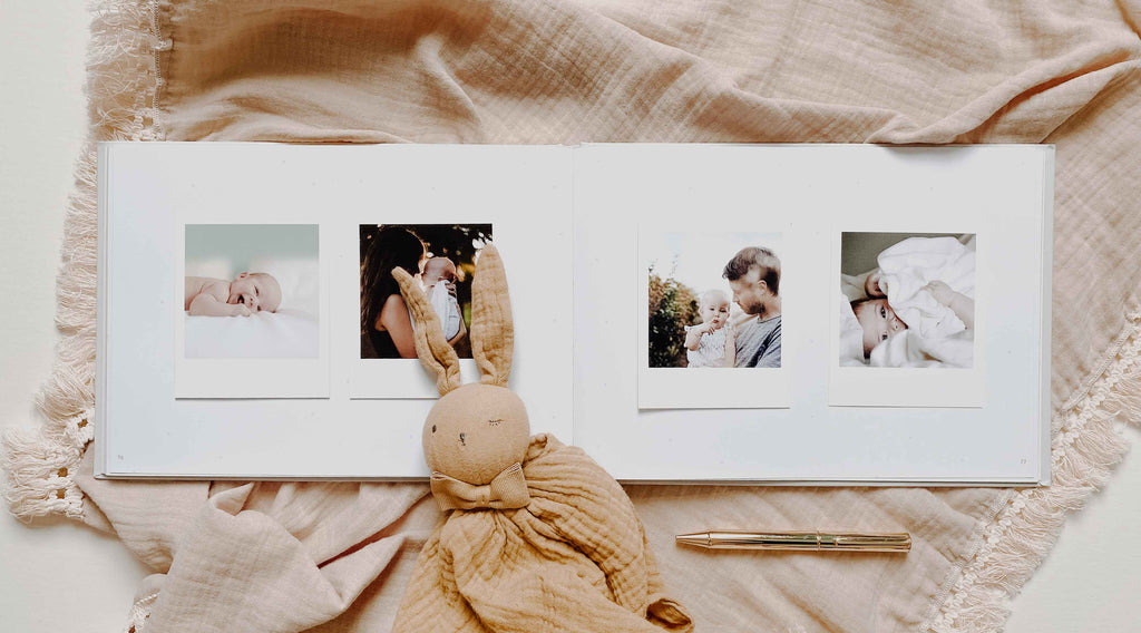 Album with family photos and a plush toy on a soft fabric background