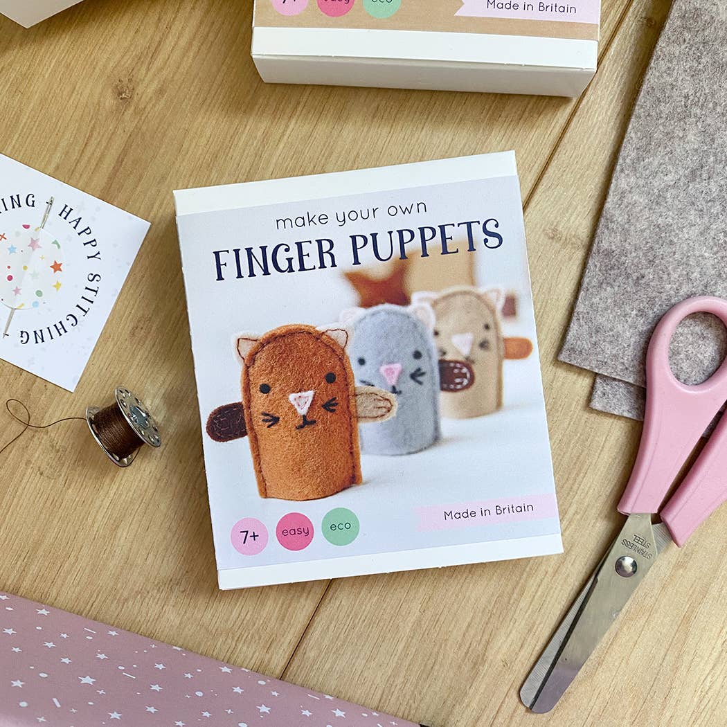 Finger puppet craft kit with scissors and materials on a wooden surface