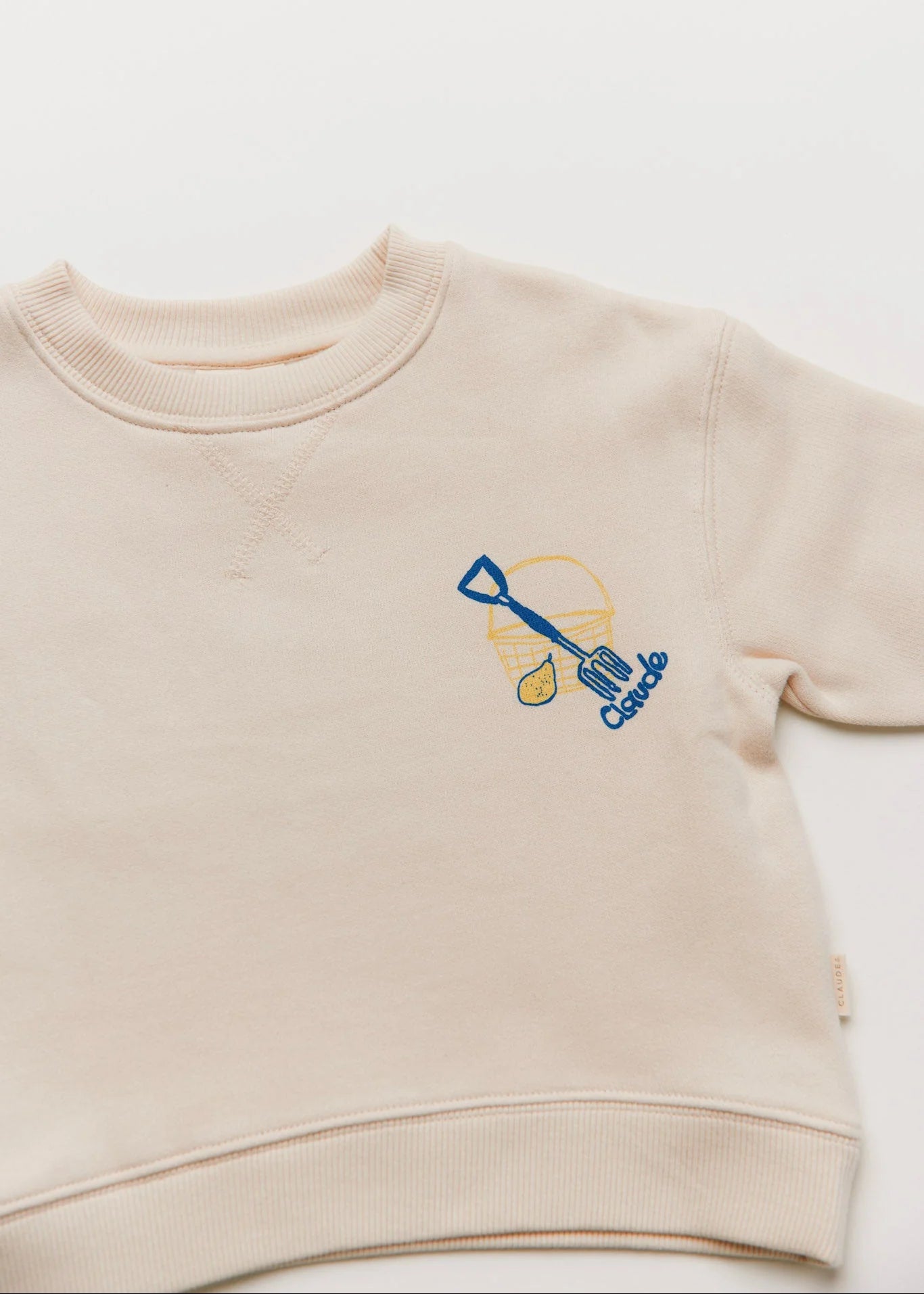 Beige sweatshirt with a blue and yellow design on a white background