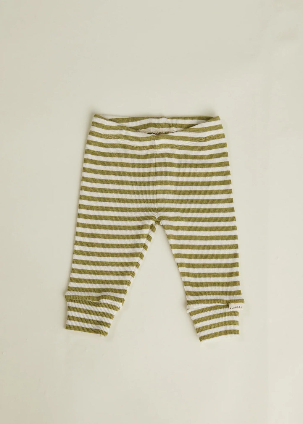 Green and white striped baby leggings on a beige background