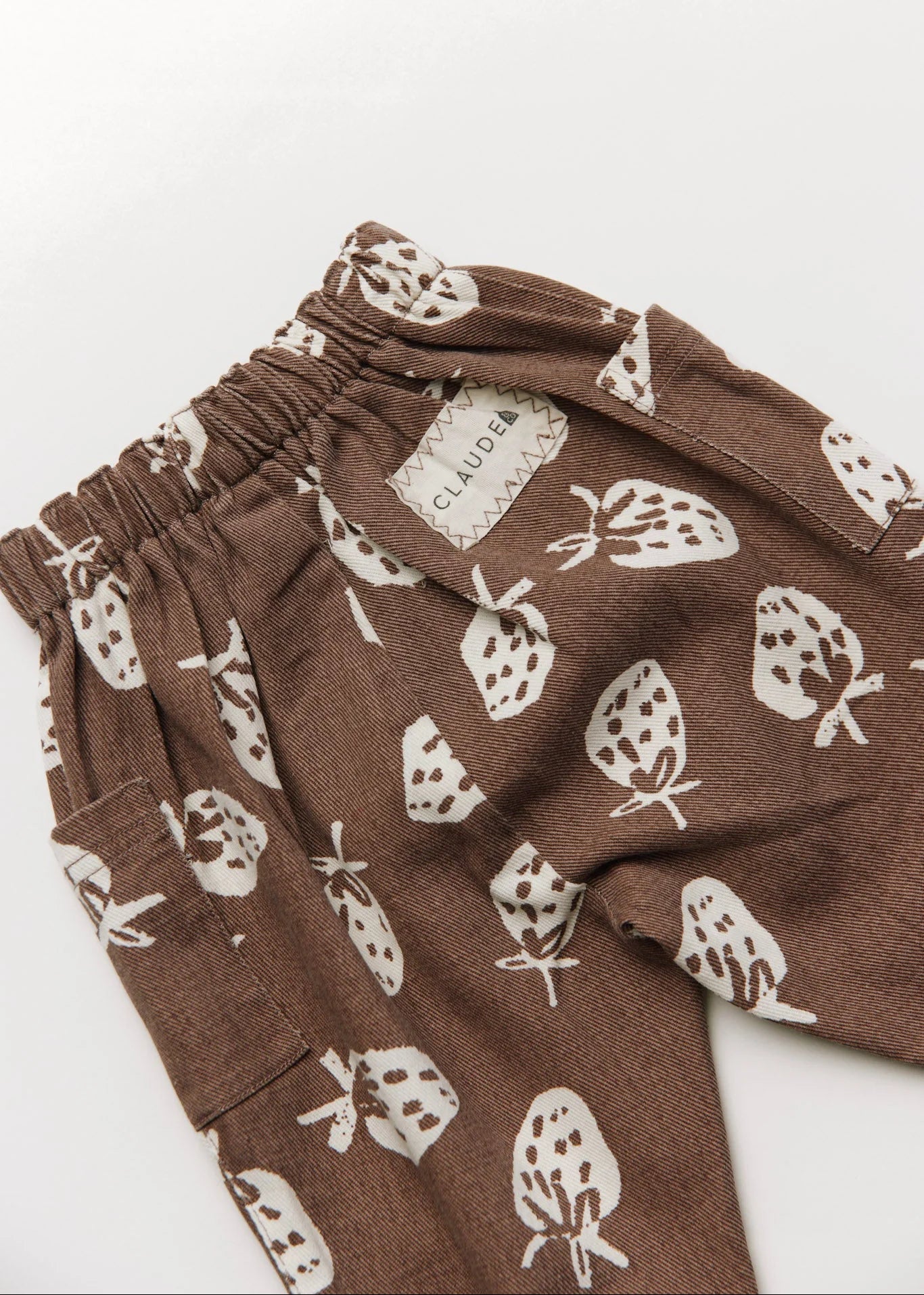 Brown pants with white strawberry pattern on a white background