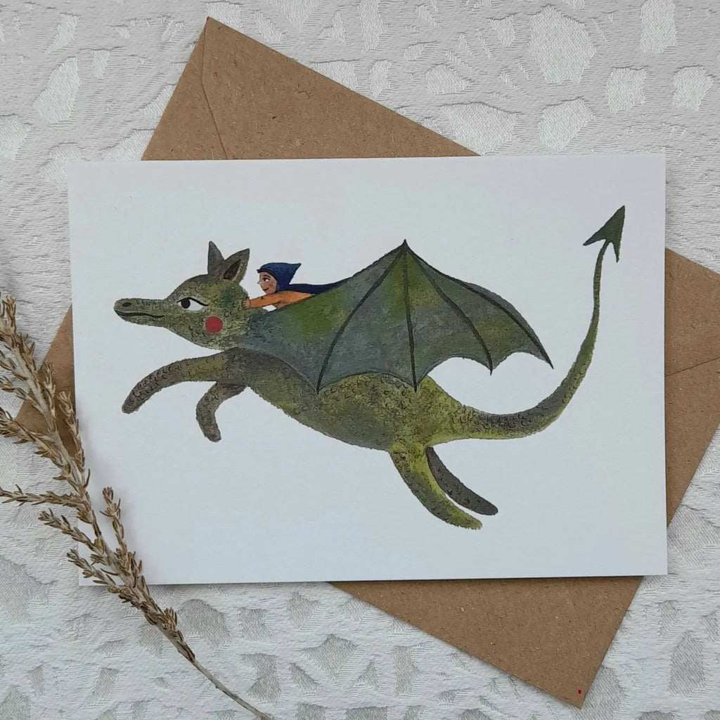 Card with a dragon illustration and a small figure on a textured surface with an envelope.