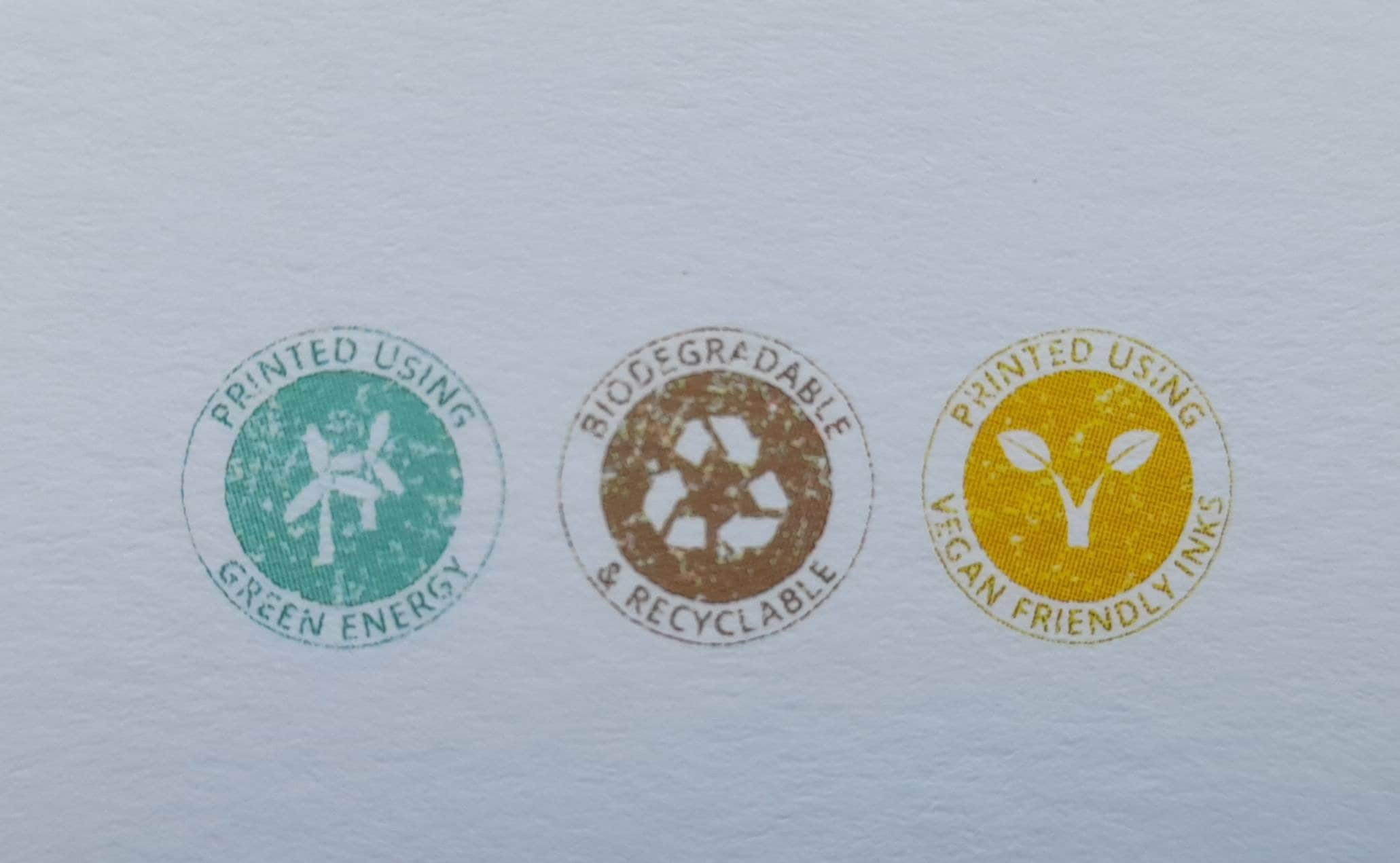 Three circular eco-friendly labels on a light gray background