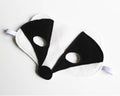 Black and white raccoon mask on a light gray background