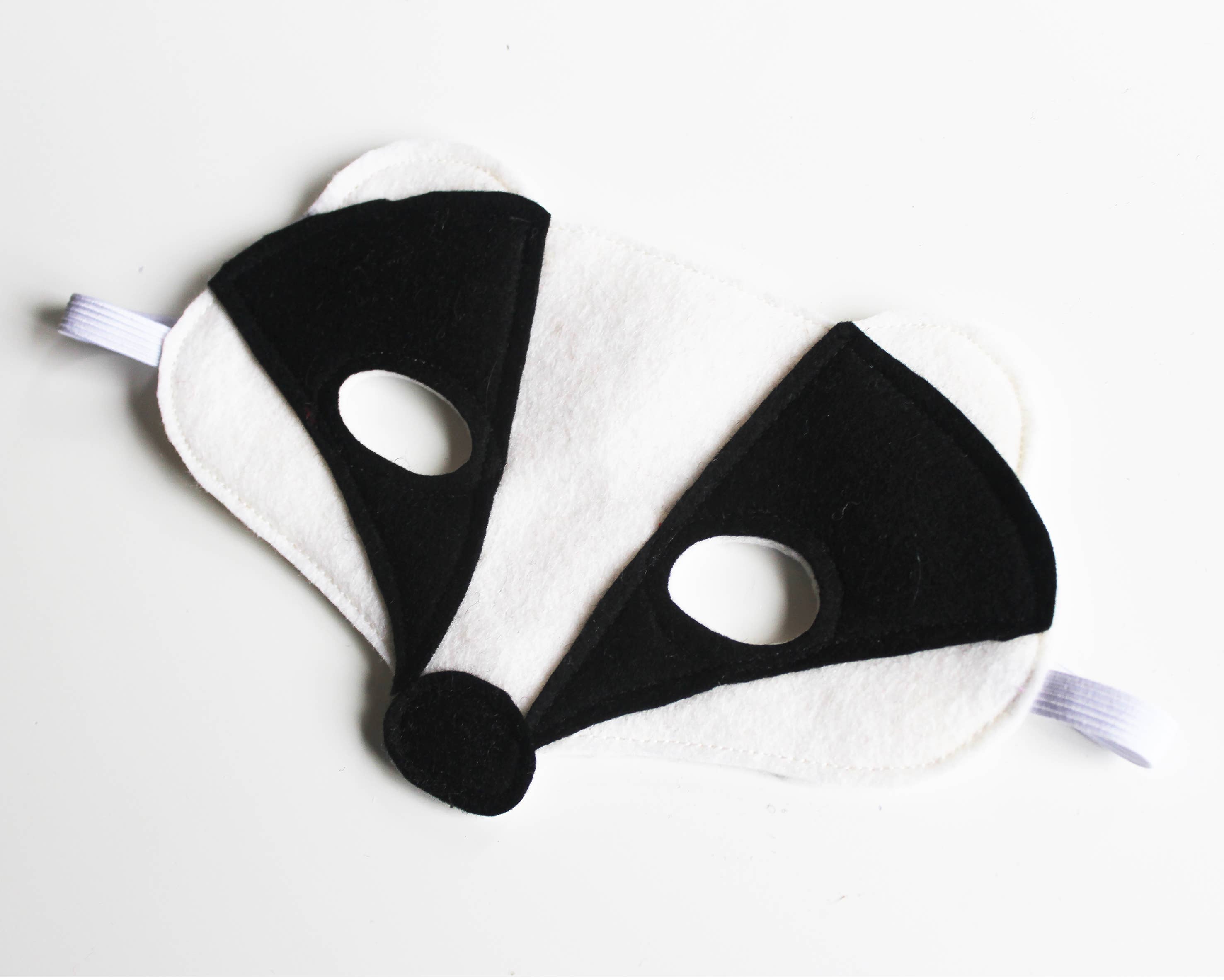 Black and white raccoon mask on a light gray background