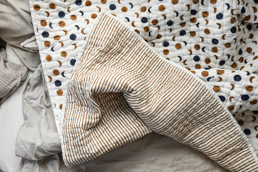 Textured fabric with a pattern of moons and tripes on reverse on a neutral background