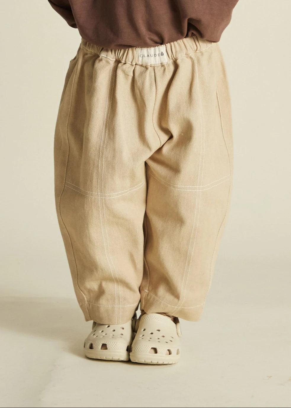 Beige pants worn by a person on a beige background