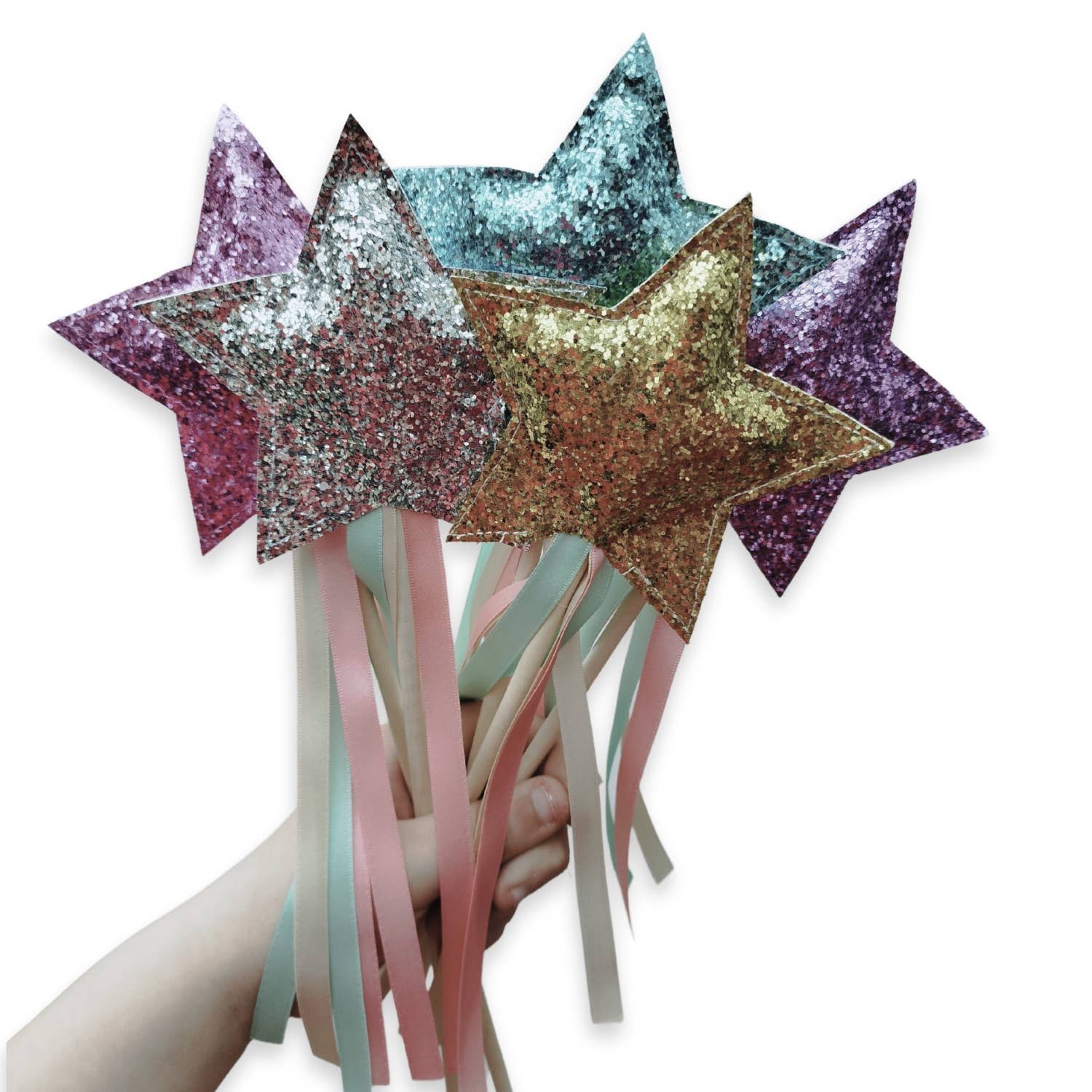 Star-shaped wands with glittery finishes and ribbons held by a hand on a white background