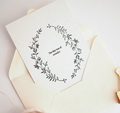 Greeting card with floral wreath design and text on a matching envelope.