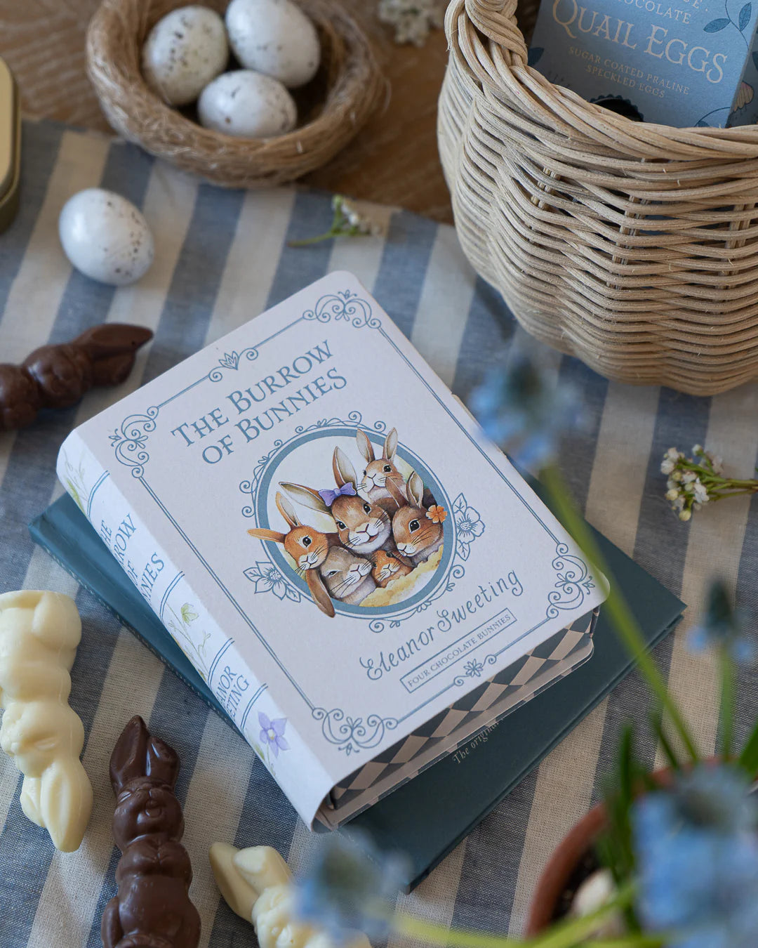 Book containing chocolates titled 'The Burrow of Bunnies' on a table with Easter decorations