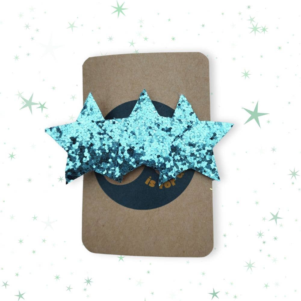 Blue glittery star-shaped hair clips on a brown card with a white background