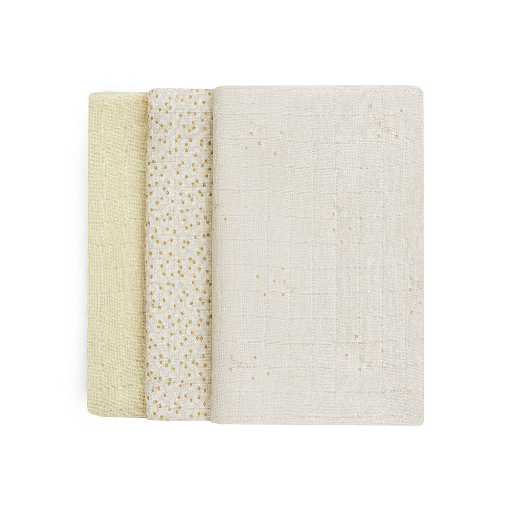 Three muslin swaddles in beige, white, and a patterned design on a white background