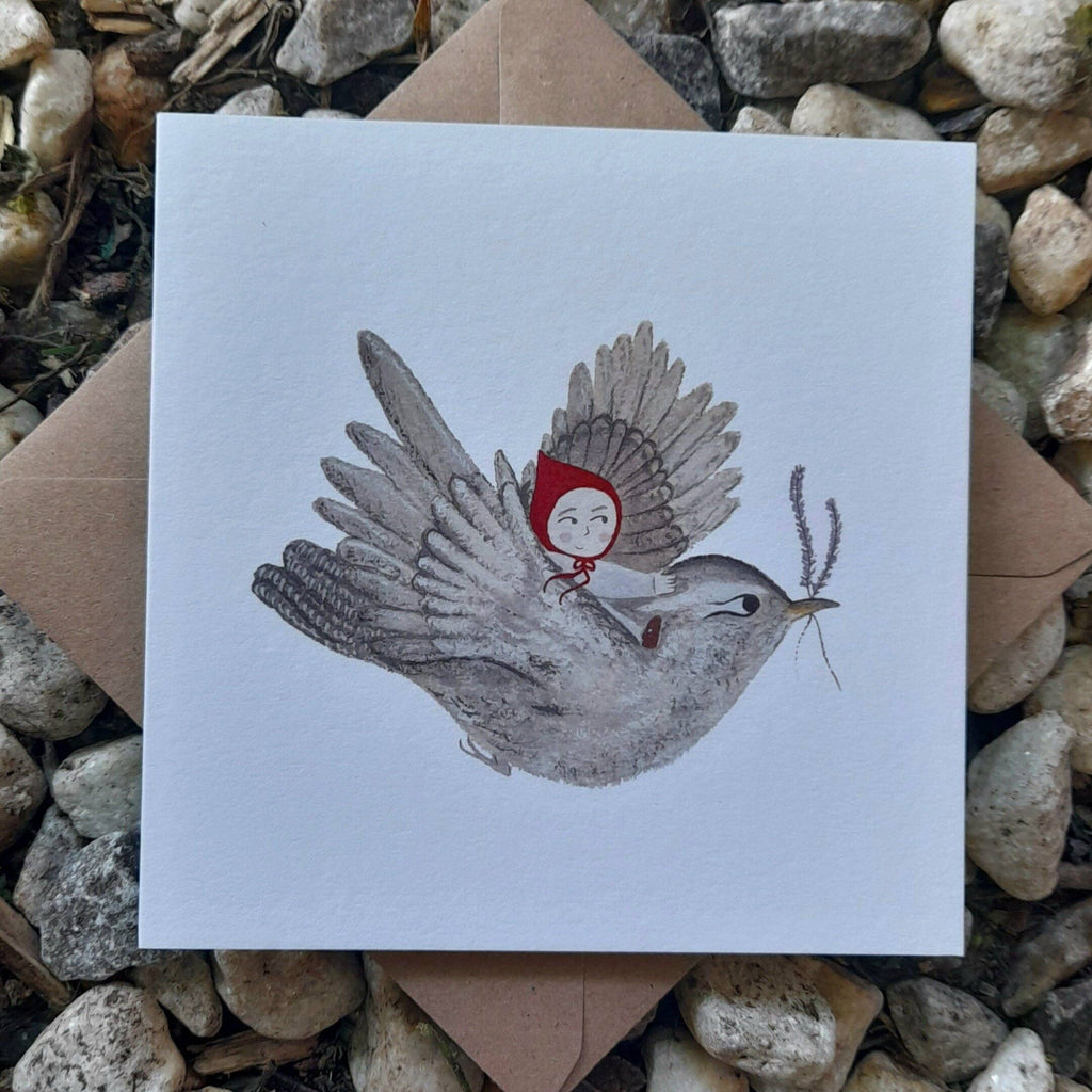 Illustration of a bird carrying a girl with a red hood on a white card, surrounded by stones.